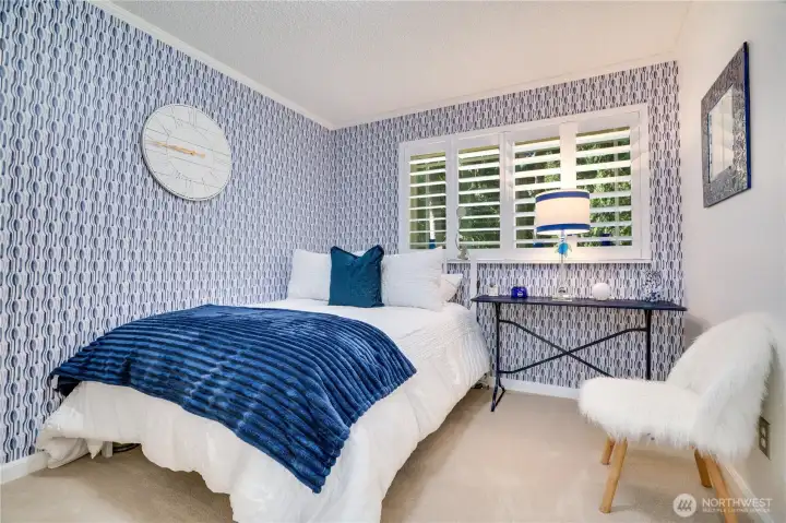 Cheerful guest bedroom with plantation shutters and designer wallpaper. Cheerful guest bedroom with plantation shutters and designer wallpaper.