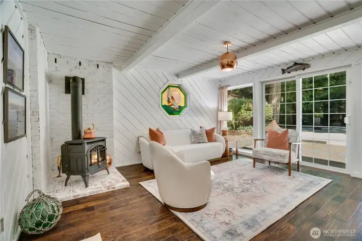 Downstairs surprise: painted cedar paneling, exposed beams & a gas stove against whitewashed brick. Downstairs surprise: painted cedar paneling, exposed beams & a gas stove against whitewashed brick.