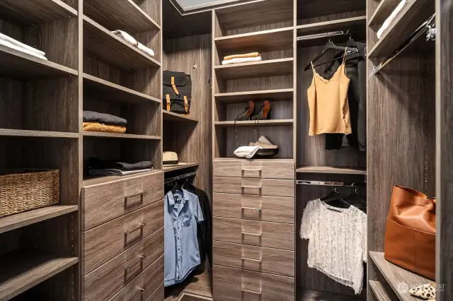 Custom primary closet with two locking jewelry drawers and space for a small safe. Two additional closets with custom finishes and lighting. Primary bath also features skylights with remote control.