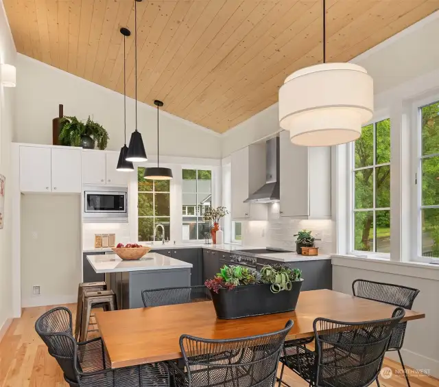 The large, pine paneled vaulted ceiling dining space is generous and ready for Thanksgiving dinner! Light filled, south facing spaces are wrapped with custom painted cabinetry.