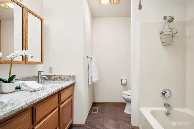 Large primary bathroom with dual sink vanity and tub.