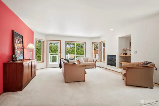 Large picture windows bring in tons of natural light to this large living room with gas fireplace.