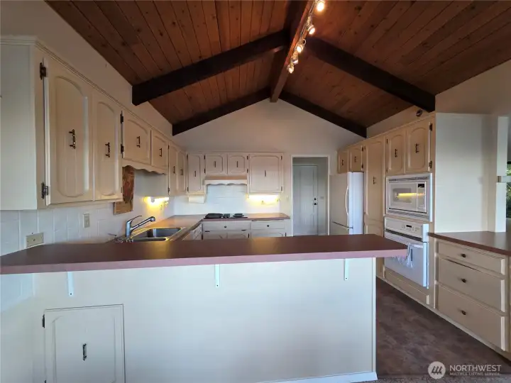 kitchen with lots of cupboard space, and custom ceiling beams