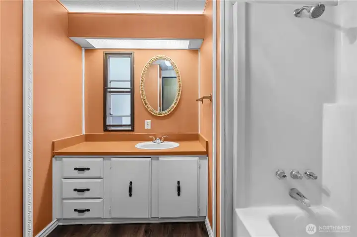 Bathroom off hallway has another large tub.