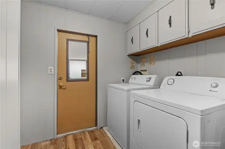 Laundry room has some linen storage and exits onto the carport.
