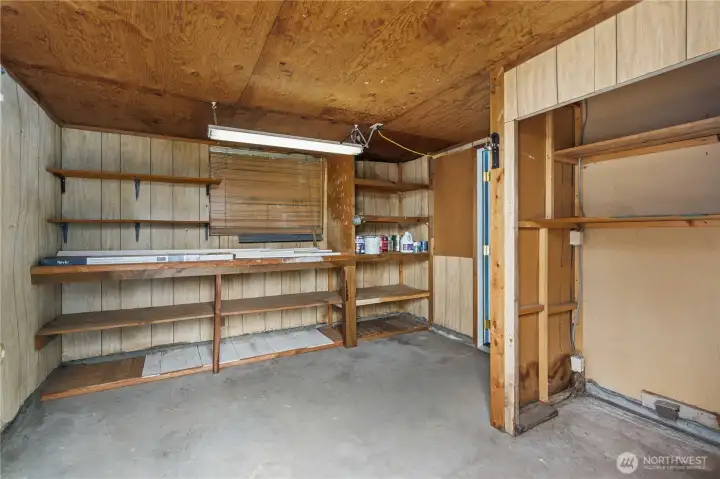 The larger of the two storage areas has a work bench and a window.
