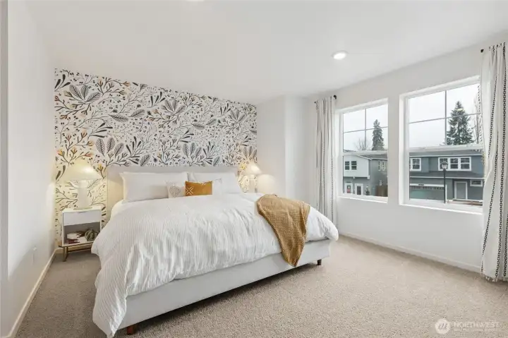 Spacious primary bedroom with large windows allowing for plenty of natural light.