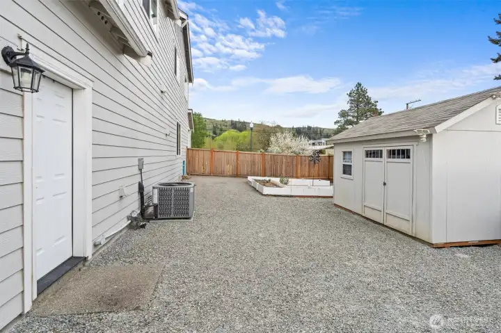 The side yard has a huge outbuilding, raised garden beds and room for more parking