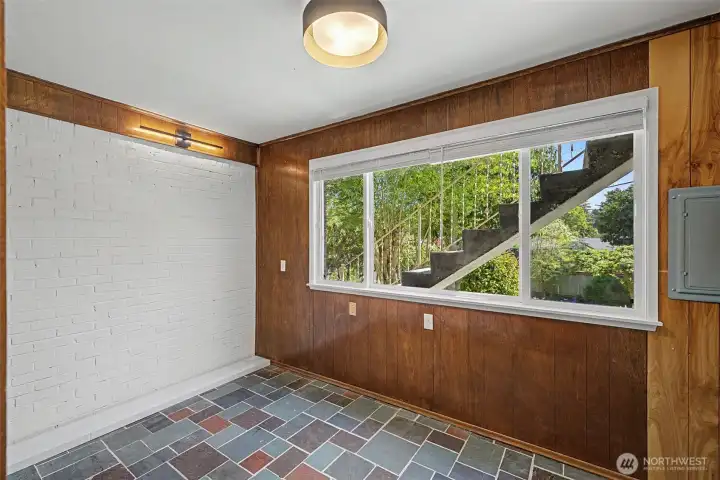 Office with brick walls, book shelves, paneling, tile floor