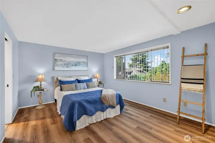 This spacious primary bedroom serves as a serene retreat, featuring expansive large windows that bathe the room in abundant natural light.