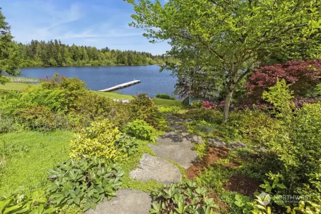 On one side of patio a stone pathway leads you through the gorgeous mature landscaping and down to the lake.