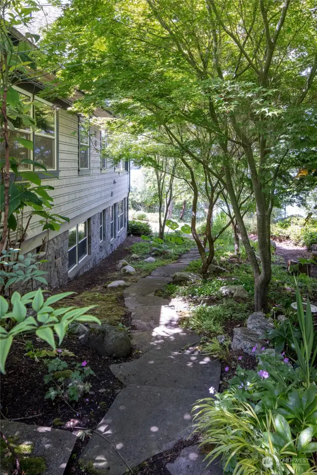 Stones from the studio/office lead to the waterfront garden side of the property.