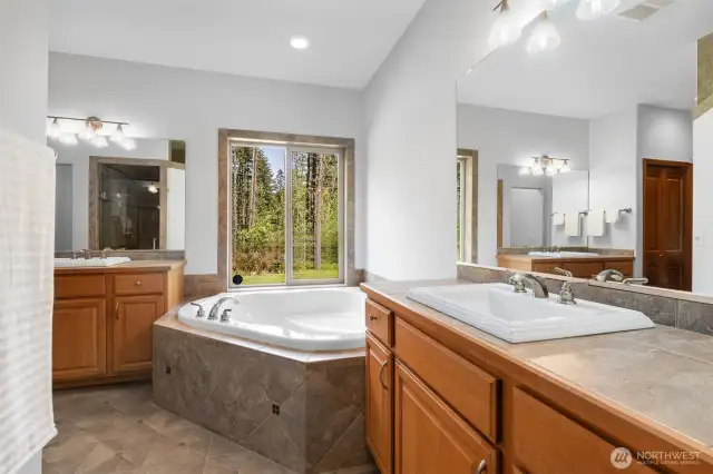 Soak your troubles away in the deep corner tub. His and her vanities.