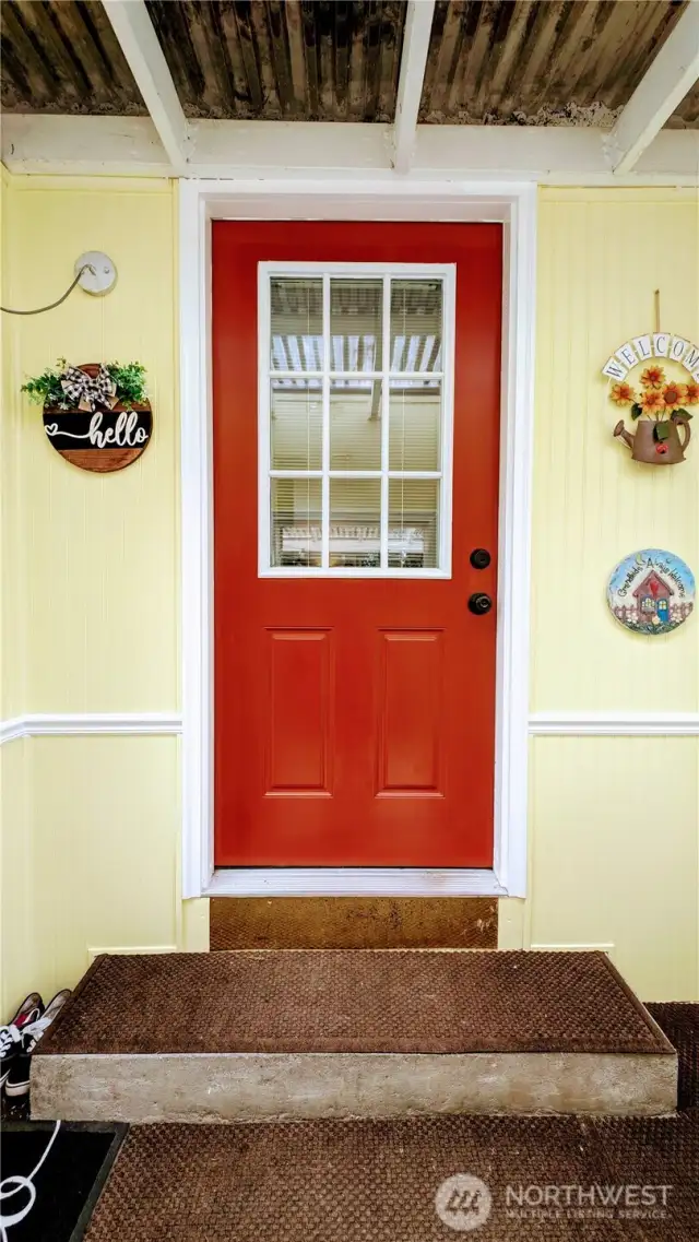 A cheerful pop of red sets the tone at this welcoming front entry, framed by sunny yellow siding that says “hello” before you even knock - hinting at the warmth and personality that awaits inside.