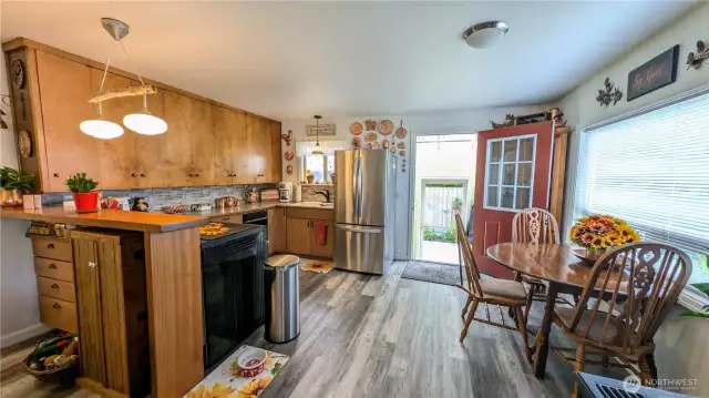 With warm wood tones, stainless steel accents, and sunny pops of color, this inviting kitchen and dining nook is equal parts functional and welcoming. Enjoy the ease of an open layout, updated appliances, and charming decor that makes every meal feel like a special occasion—whether you're hosting friends or savoring your morning coffee under the glow of custom pendant lights.