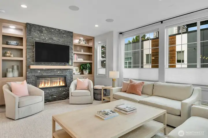 Numerous custom built ins and recessed dimmable lighting flank your rock-faced fireplace.