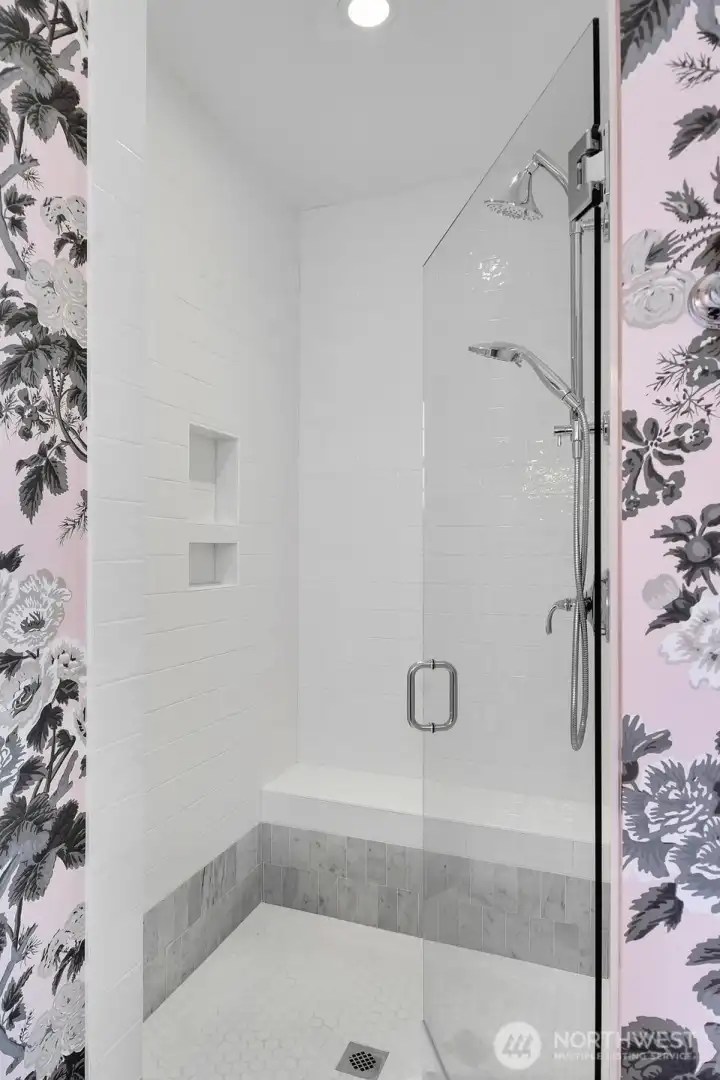 Upgraded shower with seat and niche.