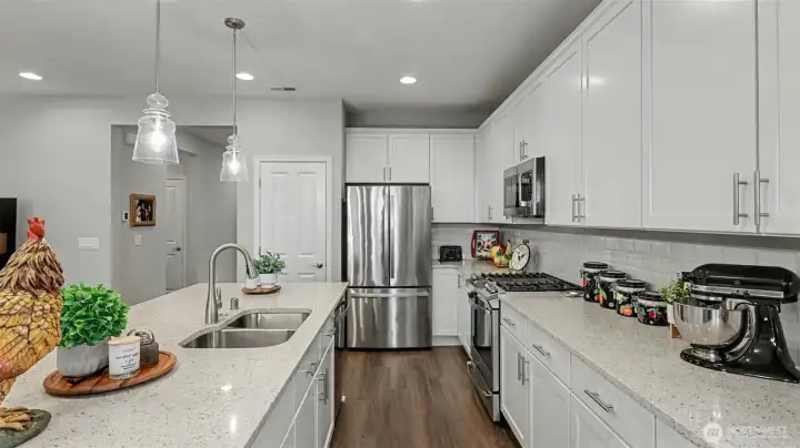 White quartz counters and cabinets gives this kitchen a sense of warmth and style
