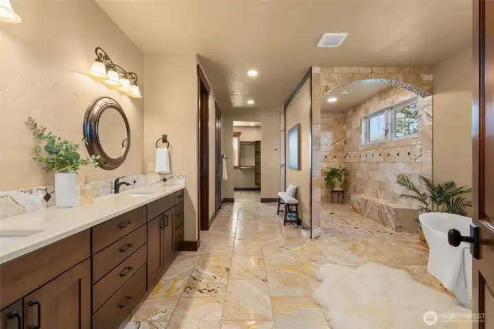 Primary Bath with travertine floor and shower with soaking tub. Spacious walk in closet