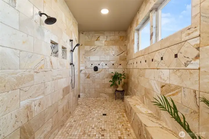 Walk in shower with travertine tile.