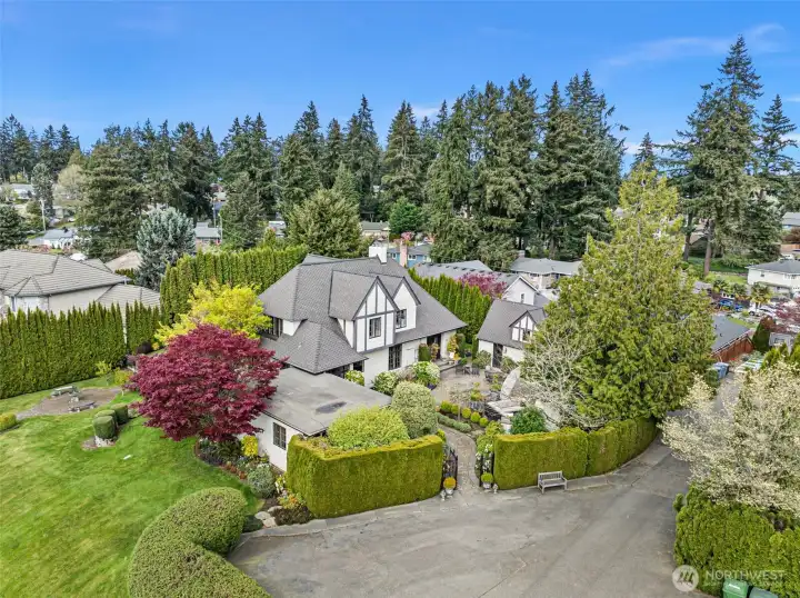 This view shows the parking pad that can fit several cars and the drive to the right leads to the garage.