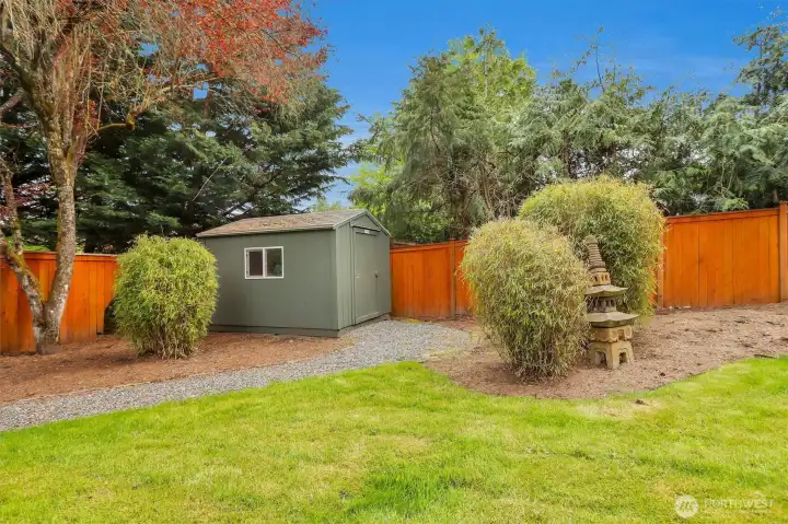 Fully fenced back yard with a shed.