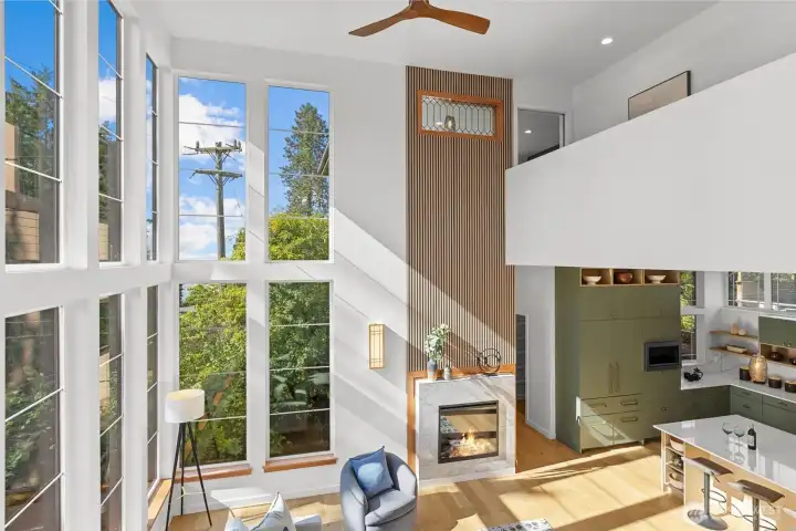 Heading upstairs to top floor, you can see how the window wall fills the home with natural light.