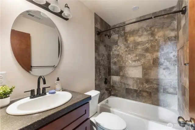 Downstairs hall bathroom has beautiful tiled bathtub