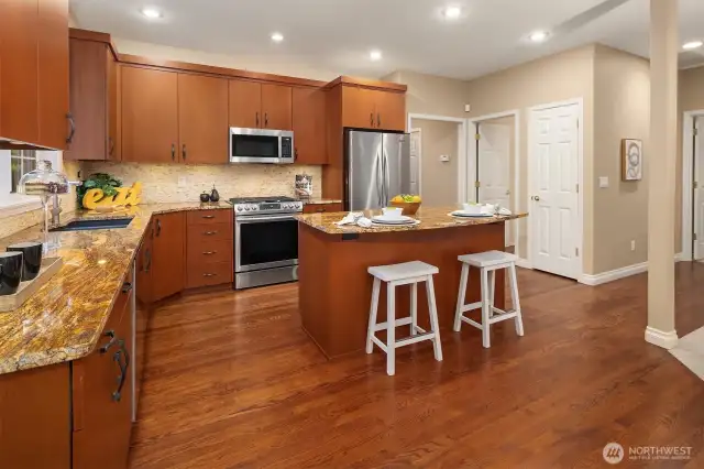 This kitchen will delight any chef, complete with stainless steel appliances, sparkling countertops, and a center island with eating bar.
