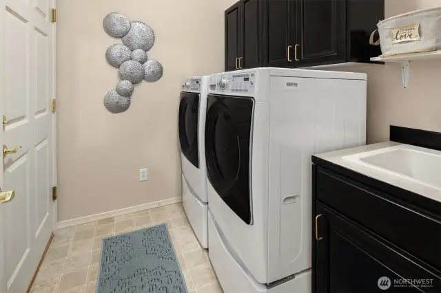 Dedicated laundry room with a convenient sink and built-ins for added storage.