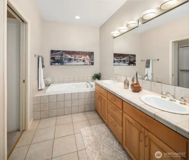 Primary bath with a soaking tub, dual sink vanity, and a separate shower.