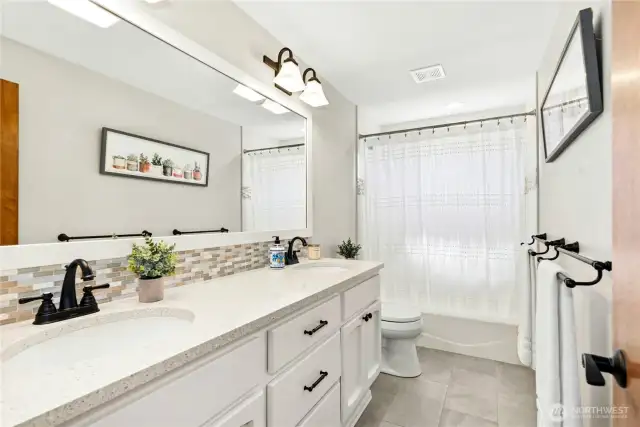 main bath with quartz counters and tiled flooring