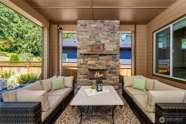 Huge, covered patio with a stone fireplace is an extension of the home and overlooks the beautiful permanent greenbelt.