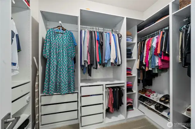 Walk-in primary closet with custom built-ins.