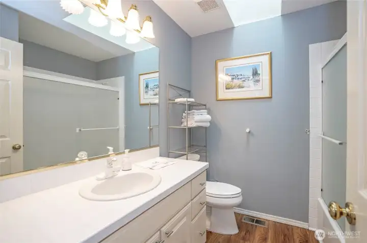 Bright and welcoming guest bath with charming tile details.