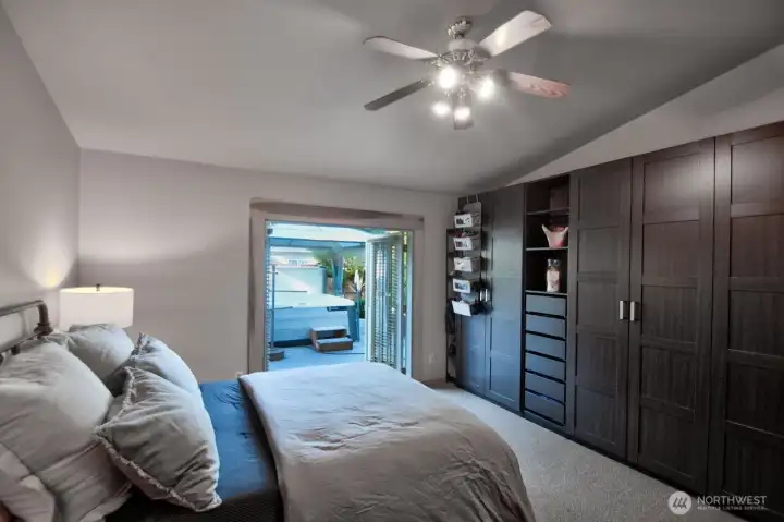 PRIMARY BED WITH FRENCH DOORS OPENS TO THE SALTWATER HOT TUB