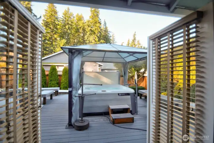 SALT WATER HOT TUB WITH GAZEBO OPENED FRENCH DOORS FROM THE PRIMARY BEDROOM