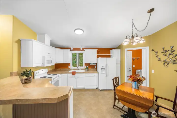 Kitchen with eating bar and room for a dining table. The laundry room and back yard entry if off of the kitchen.