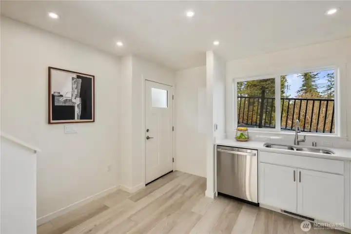 Welcoming main-level entry showcasing light wood flooring, modern finishes, and an open flow toward the living area.