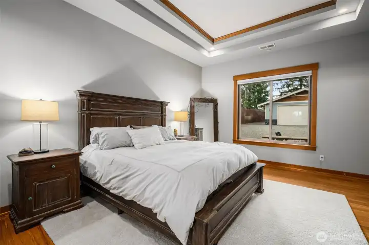Comfortable primary bedroom retreat with tray ceiling.