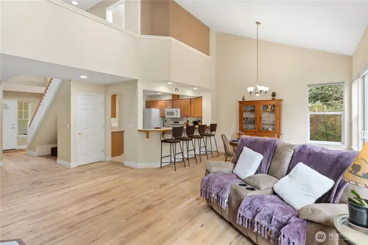 Long view of the great room, dining area and kitchen plus loft above