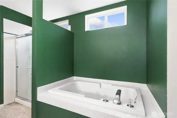 Garden tub and shower have windows that are high for natural light