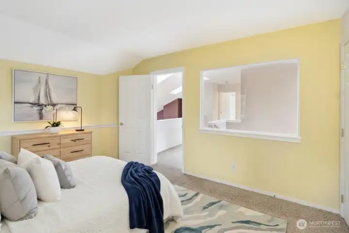 There is a white wall and window behind the bed looks into the trees and is the owners favorite view - virtual staged.