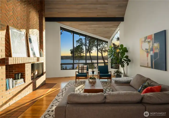 A full-height herringbone brick fireplace complete with firewood storage space anchors the south wall of the room. A full-height herringbone brick fireplace complete with firewood storage space anchors the south wall of the room.