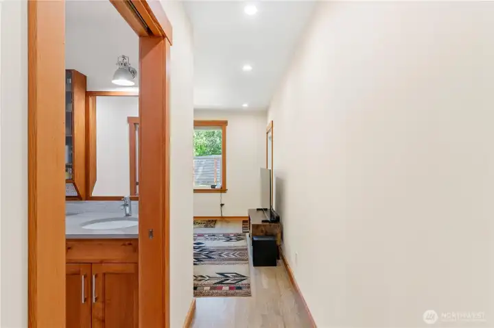Entrance to primary suite, 3/4 bath on left