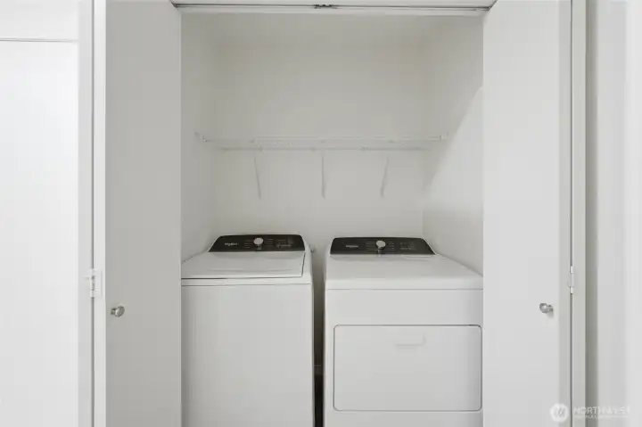 Dedicated laundry area with additional storage space.