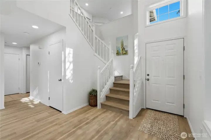 Open entry with dramatic ceiling height and sightlines to the upper level.