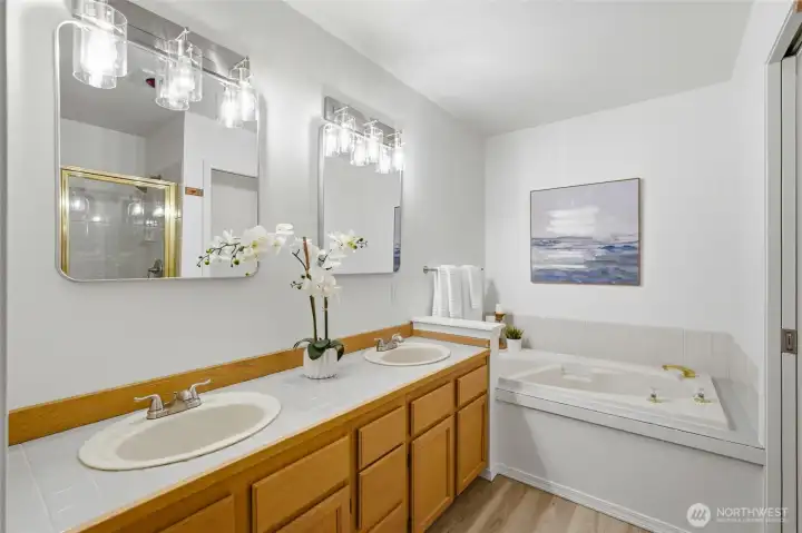 Primary bath featuring dual vanities, soaking tub, and separate shower.