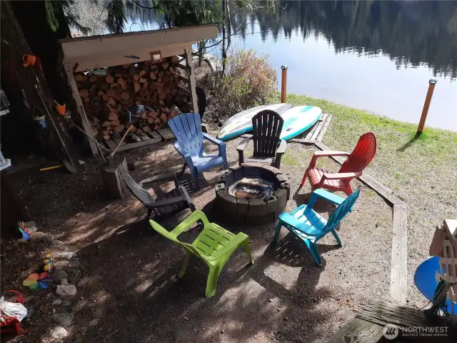 seating around fire pit with wood storage