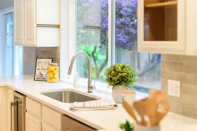 Polished quartz countertops offer a clean, elegant surface that's both durable and low-maintenance—perfect for cooking, entertaining, or casual meals. The classic subway tile backsplash adds texture and visual interest while complementing the kitchen’s crisp white cabinetry. New built-in wine fridge provides convenient wine or drink storage right where you want it.